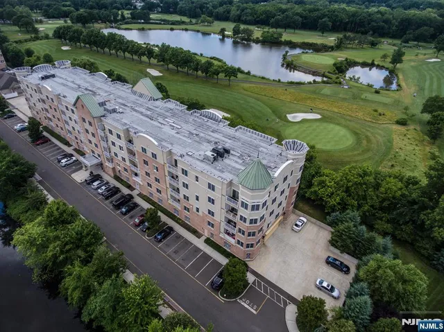 an aerial view of a house with a garden and lake view