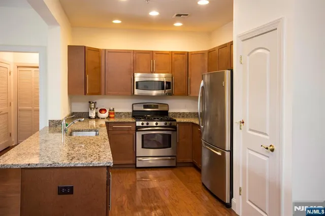 a kitchen with kitchen island granite countertop stainless steel appliances and a sink