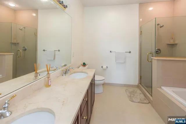 a bathroom with a granite countertop sink a toilet and shower