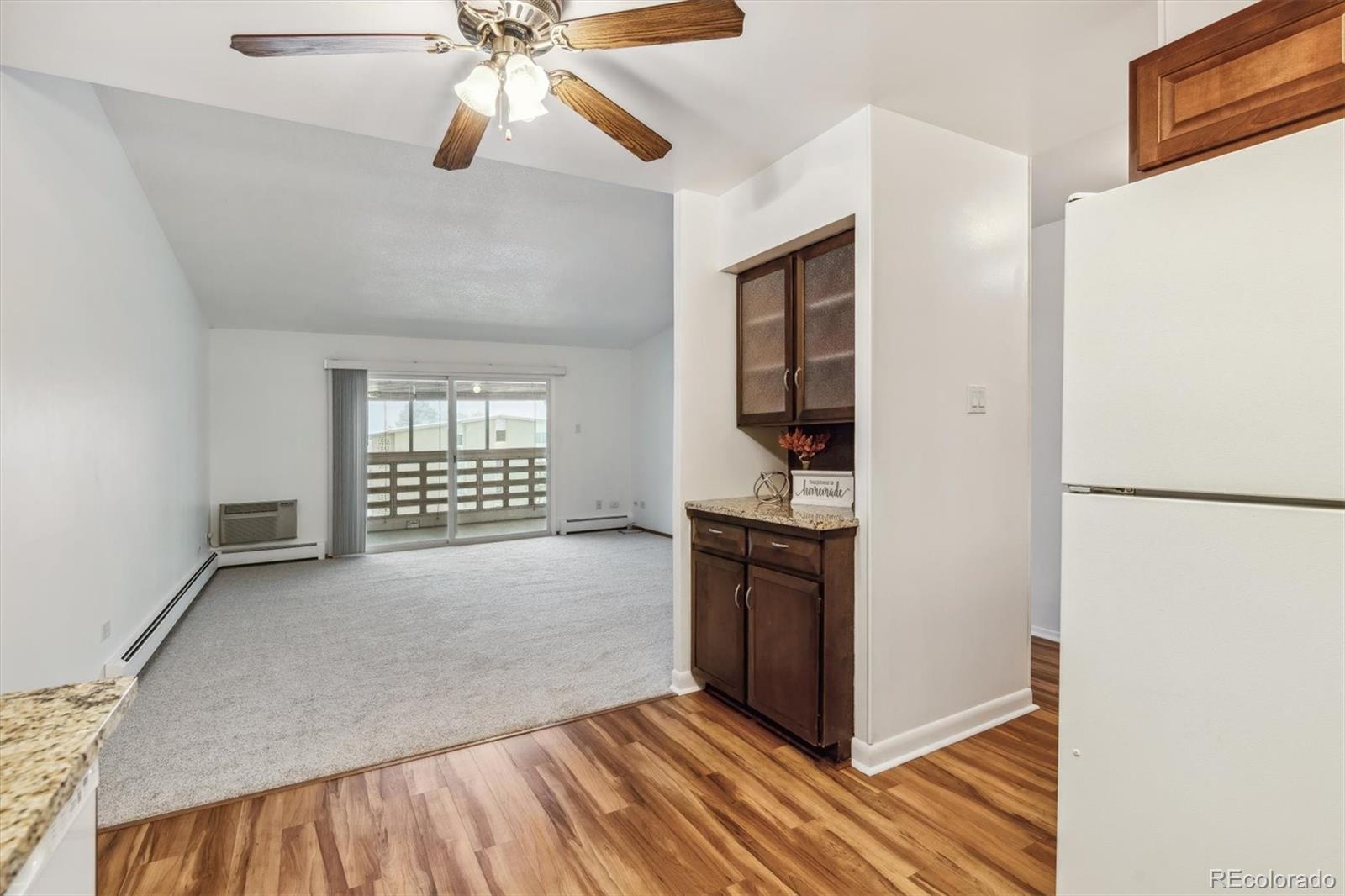 610 South Alton Way, Unit 8D Denver, CO 80247 - Photo 8 of 50 a view of kitchen and empty room with wooden floor