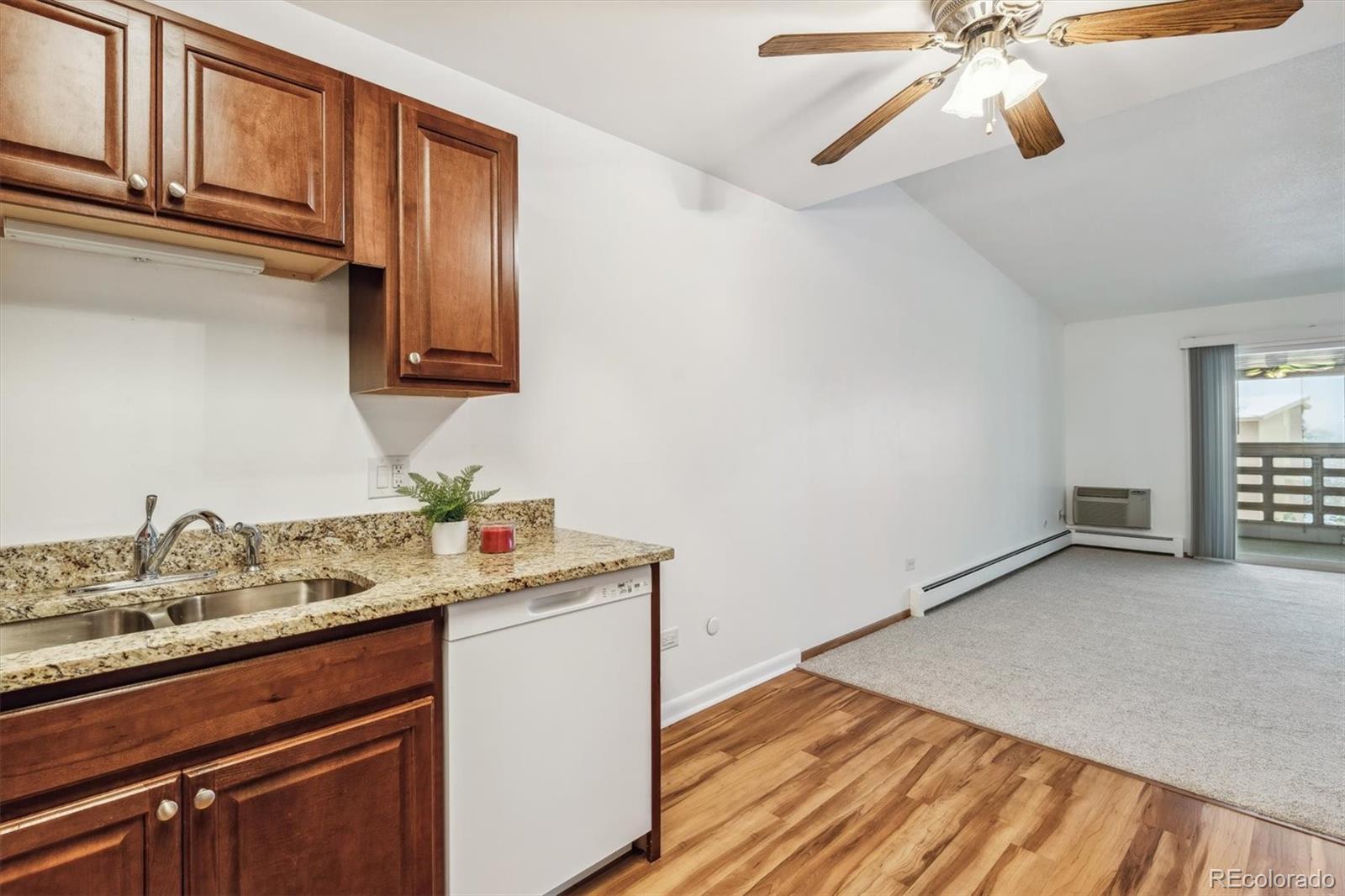 610 South Alton Way, Unit 8D Denver, CO 80247 - Photo 9 of 50 a kitchen with a sink cabinets and wooden floor