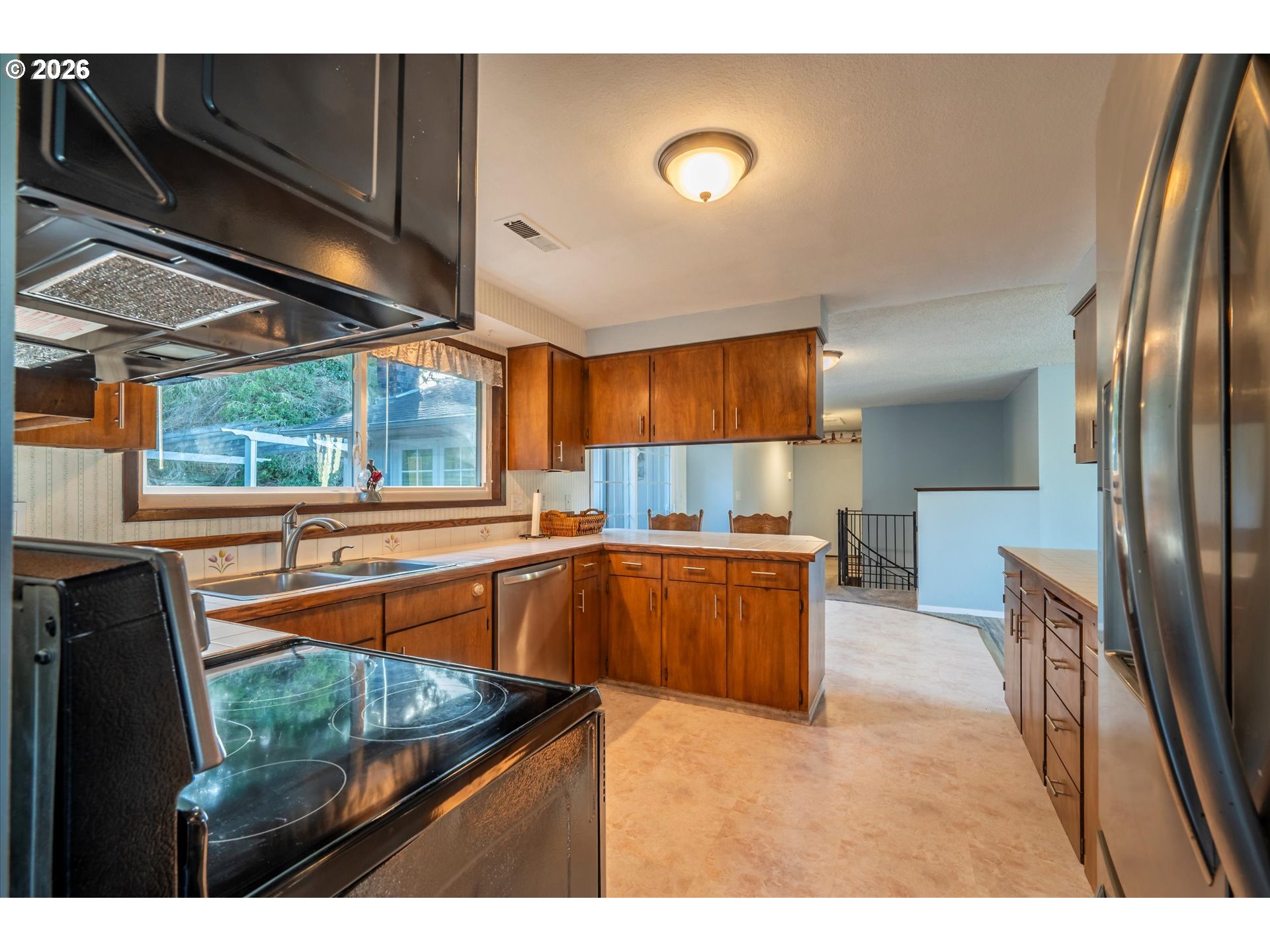 1376 D Street Coos Bay, OR 97420 - Photo 12 of 44 a kitchen with stainless steel appliances granite countertop a sink window and refrigerator