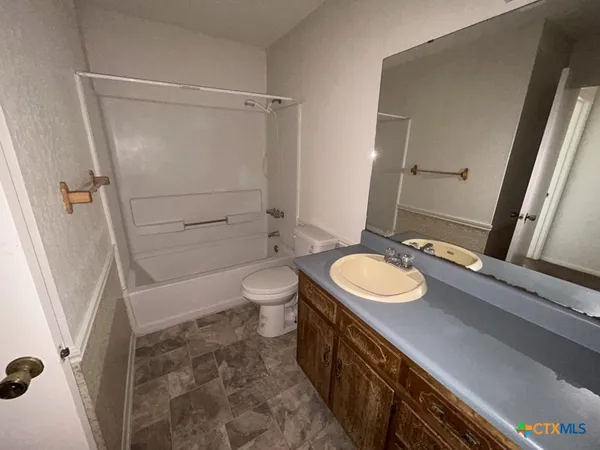 a bathroom with a sink a toilet a mirror and shower