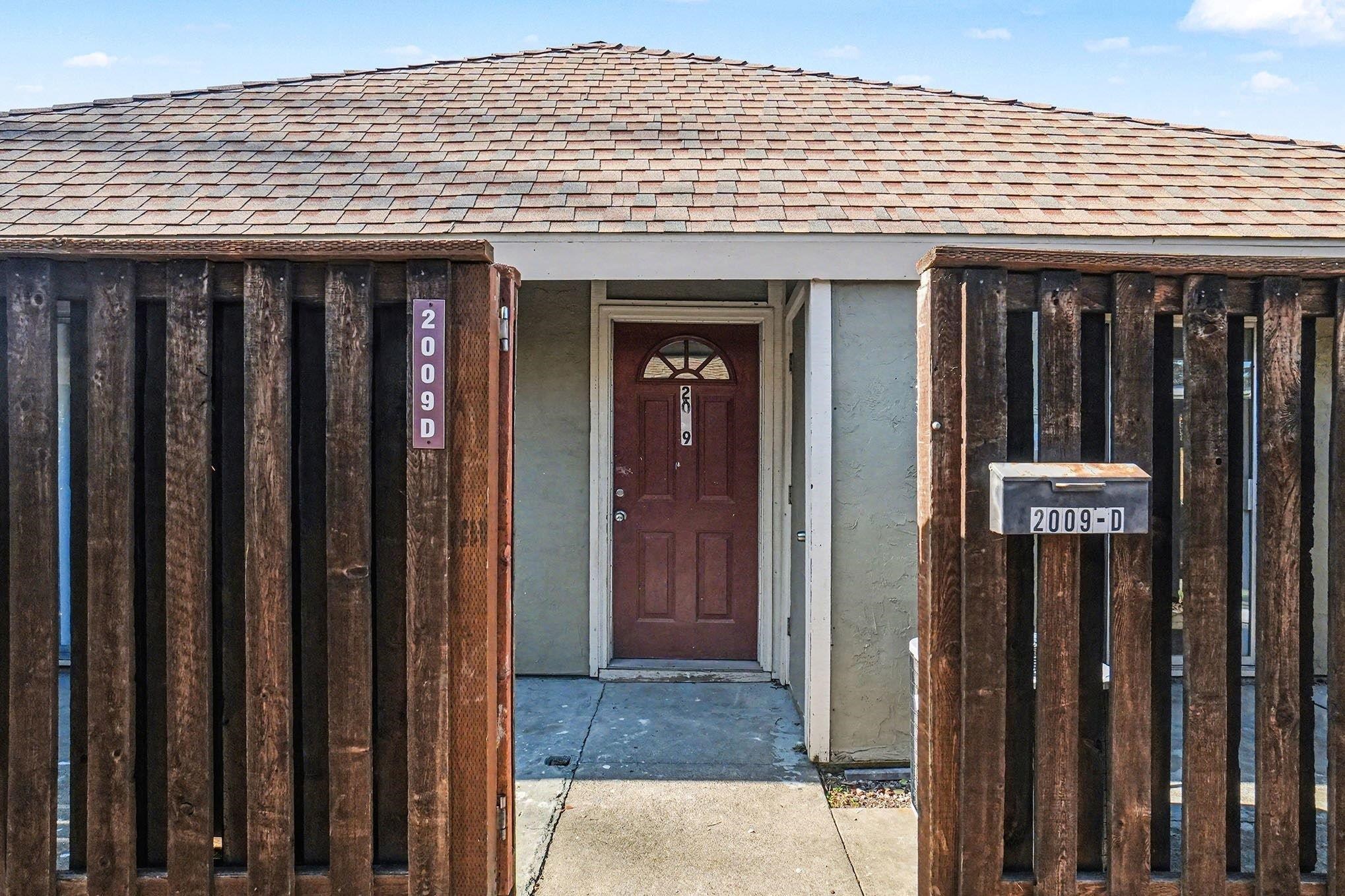 Doorway to property featuring a shingled roof and stucco siding