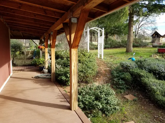 a view of a hallway with wooden floor and a bathroom