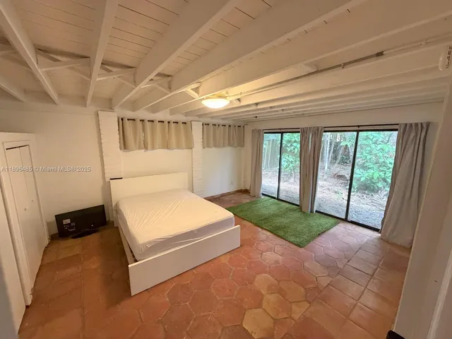 a spacious bedroom with a bed and a large window