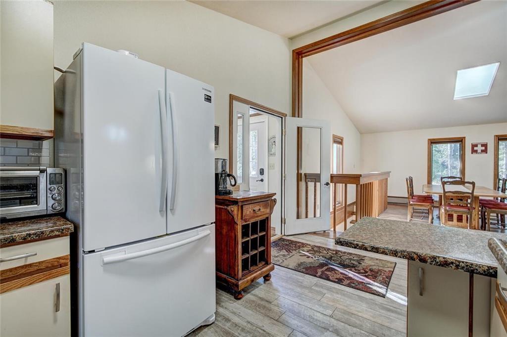 357 County Road 628 Breckenridge, CO 80424 - Photo 9 of 28 a kitchen with stainless steel appliances granite countertop a refrigerator a stove and a dining table with wooden floor