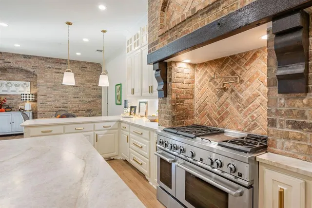a kitchen with stainless steel appliances a stove a sink and white cabinets