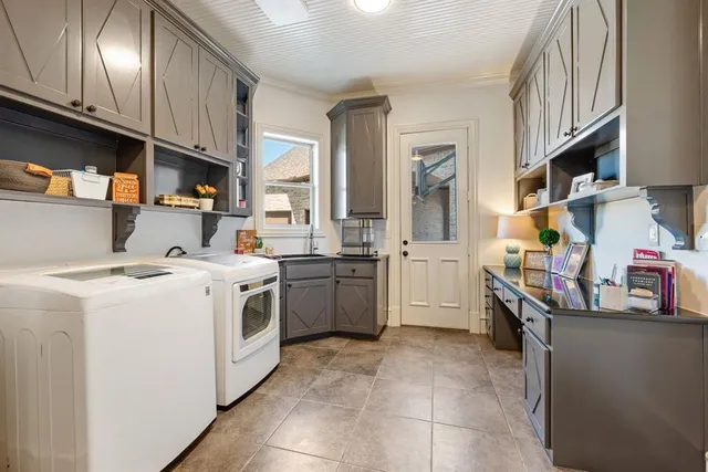 a kitchen that has a lot of white cabinets and stainless steel appliances