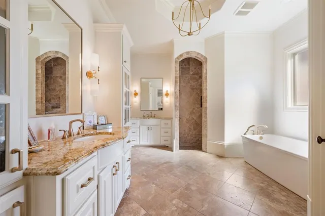 a spacious bathroom with a granite countertop sink a mirror a bathtub and shower