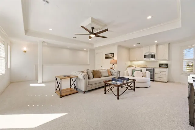 a living room with furniture kitchen view and a chandelier