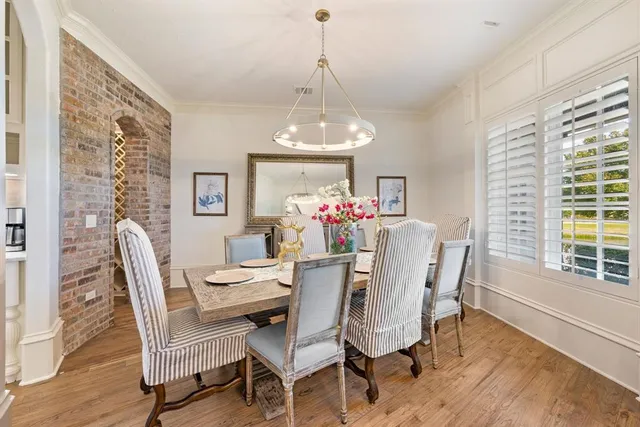 a dining room with furniture a chandelier and wooden floor