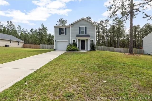 a view of a house with a yard and pathway