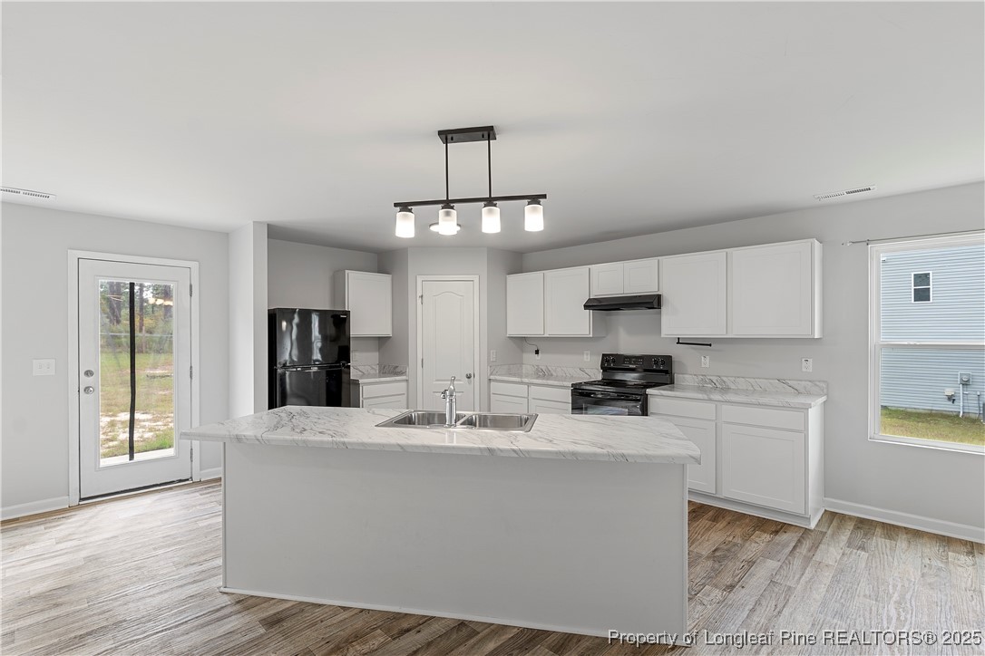 191 Mildred Way Aberdeen, NC 28315 - Photo 8 of 26 a kitchen with stainless steel appliances a sink a stove a refrigerator cabinets and a dining table