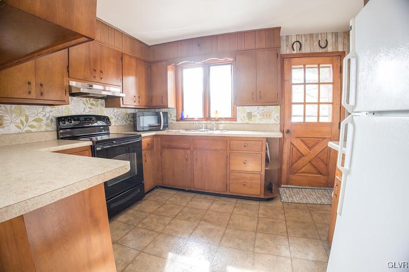 2491 Yost Road Bath, PA 18014 - Photo 23 of 42 a kitchen with a stove a sink a counter top space and cabinets