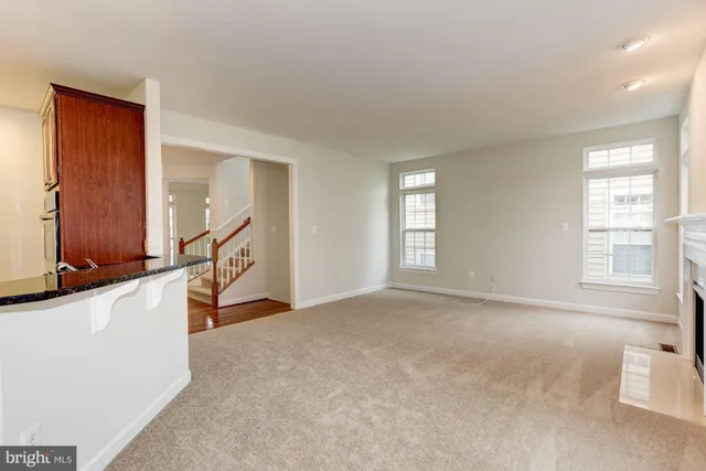 an empty room with windows and fireplace