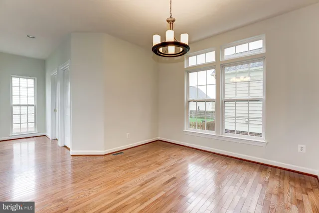 a view of a room with wooden floor and large windows