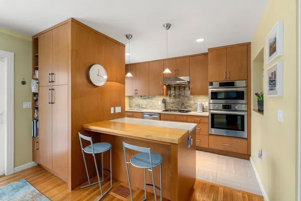 a kitchen with stainless steel appliances granite countertop a stove microwave and cabinets