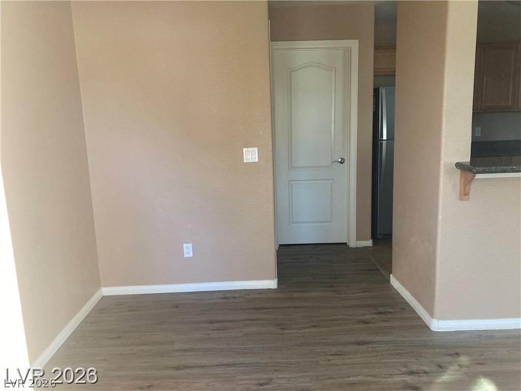 3145 East Flamingo Road, Unit 2100 Las Vegas, NV 89121 - Photo 11 of 34 Rich wood-look flooring stretches through this inviting living area, leading to a glimpse of the kitchen beyond.