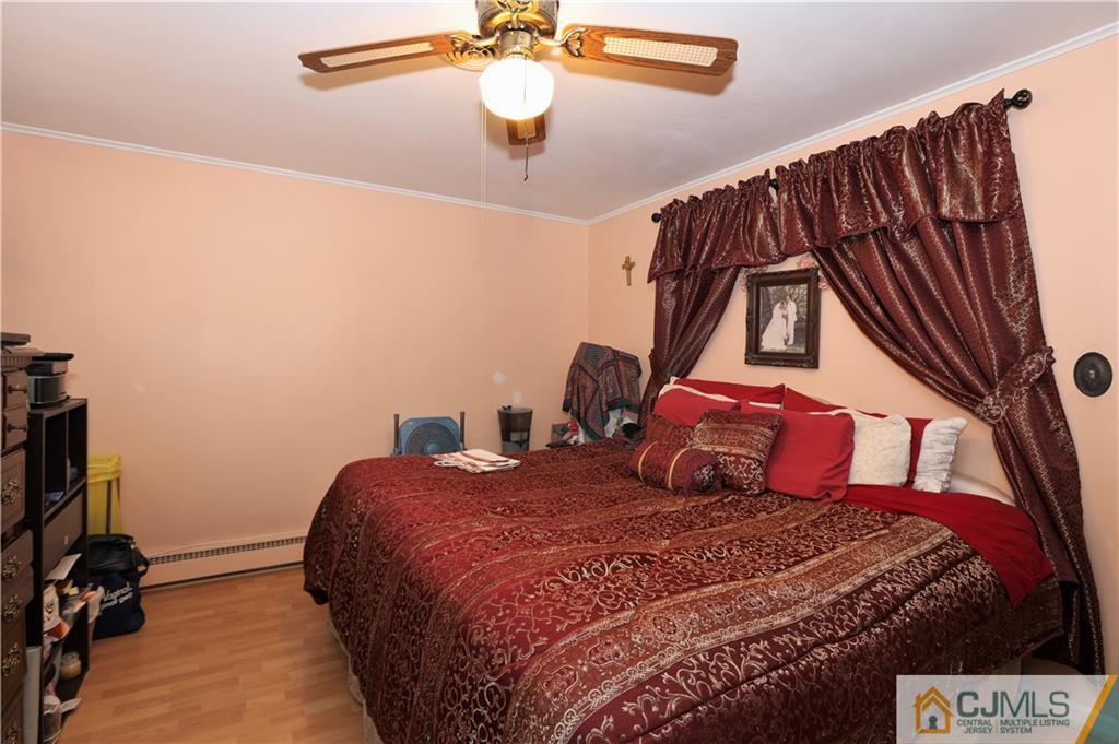 120 South Hill Road Colonia, NJ 07067 - Photo 13 of 26 a bedroom with a bed and a chandelier