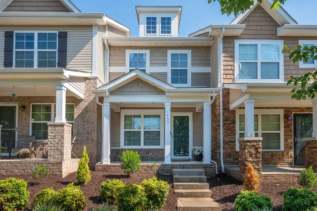 front view of a brick house with a yard