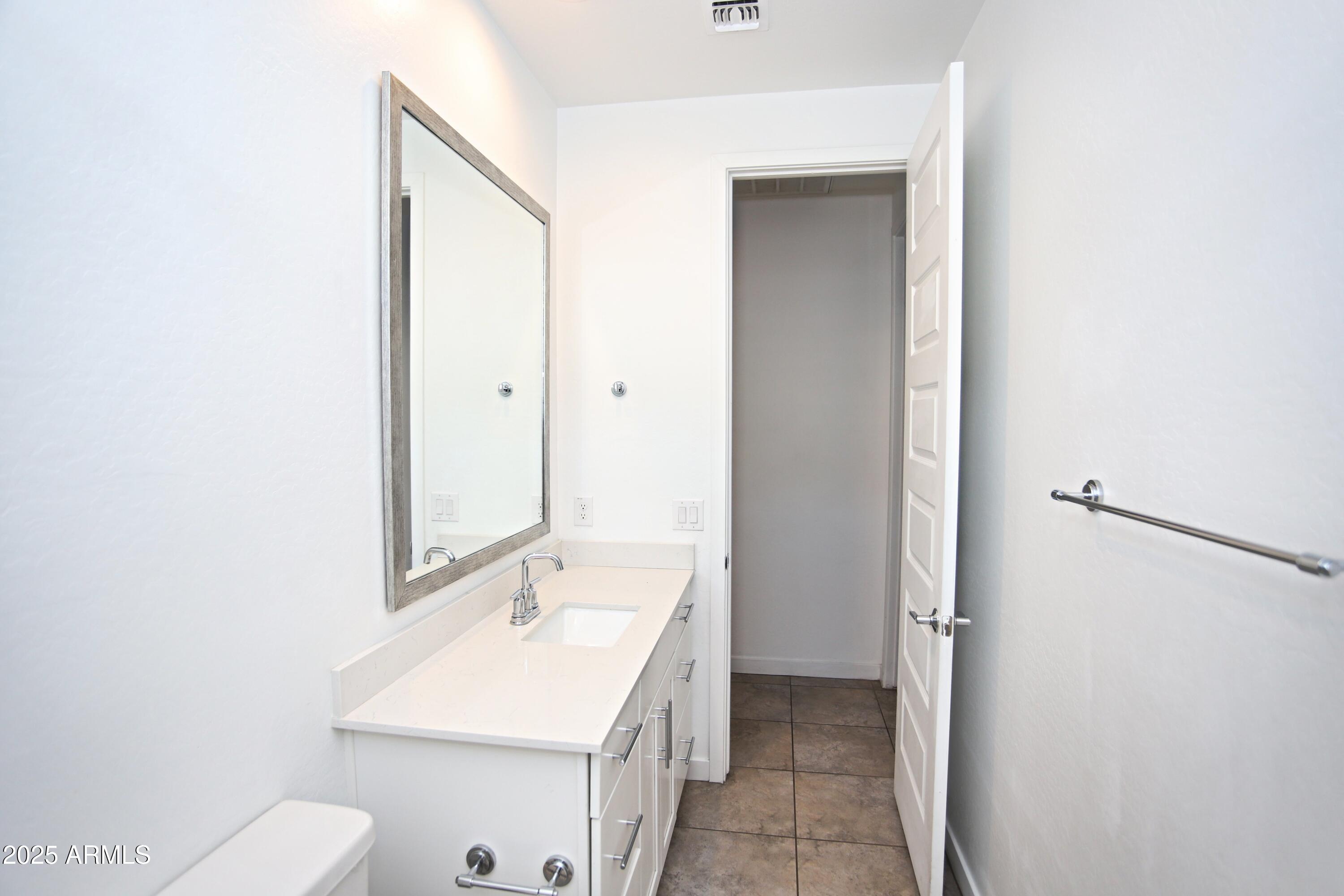 1535 West Corral Road Phoenix, AZ 85041 - Photo 11 of 39 a bathroom with a sink and mirror