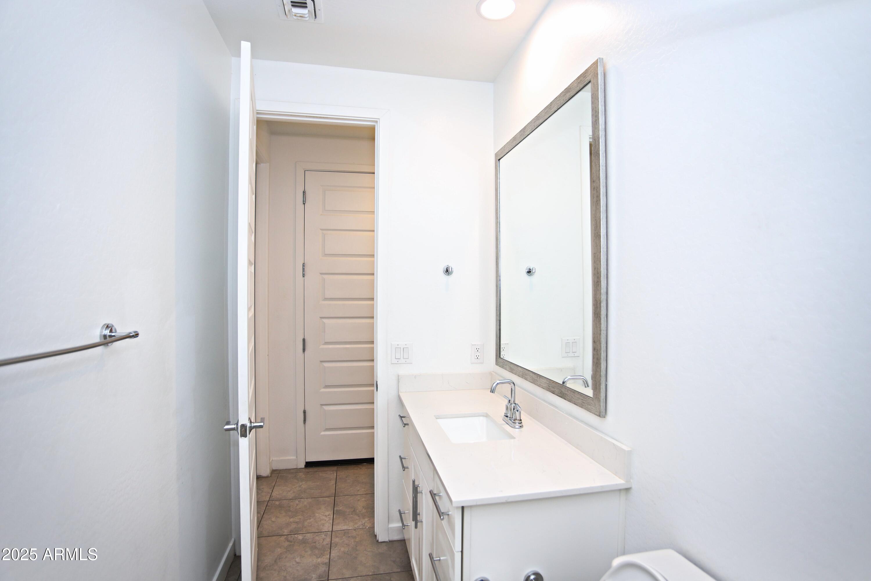 1535 West Corral Road Phoenix, AZ 85041 - Photo 17 of 39 a bathroom with a sink a toilet and vanity