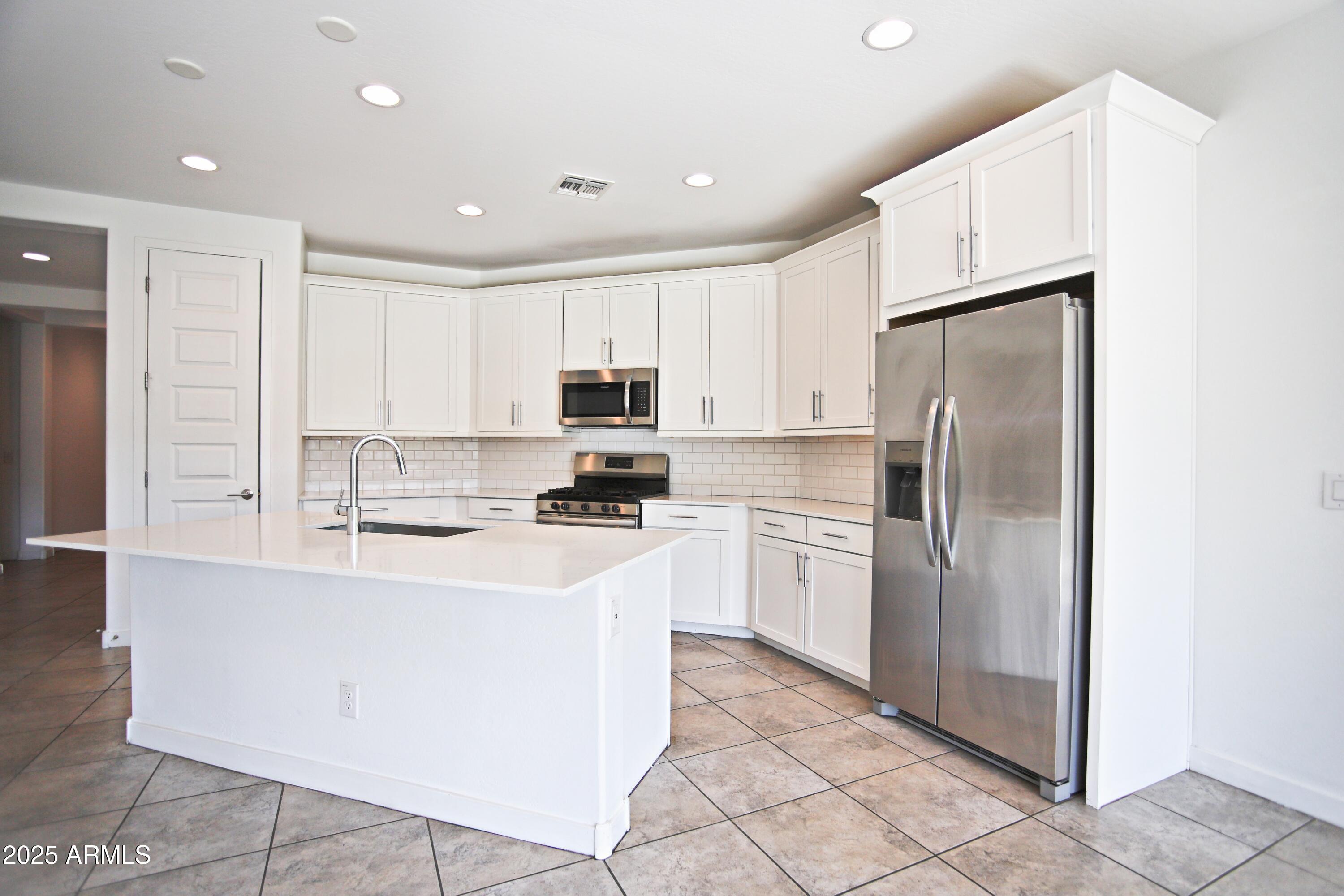 1535 West Corral Road Phoenix, AZ 85041 - Photo 20 of 39 a kitchen with cabinets and stainless steel appliances