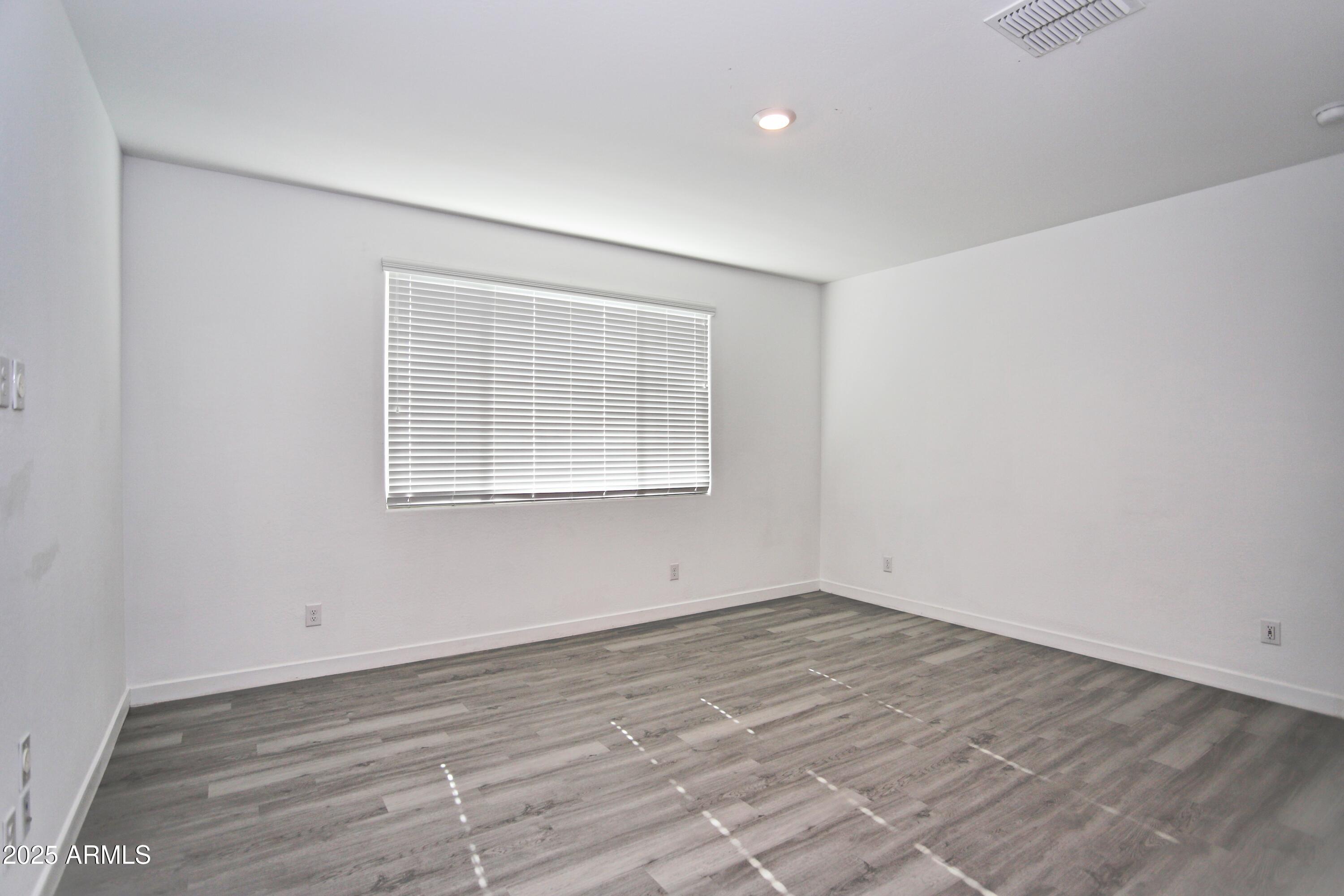 1535 West Corral Road Phoenix, AZ 85041 - Photo 23 of 39 wooden floor in an empty room with a window