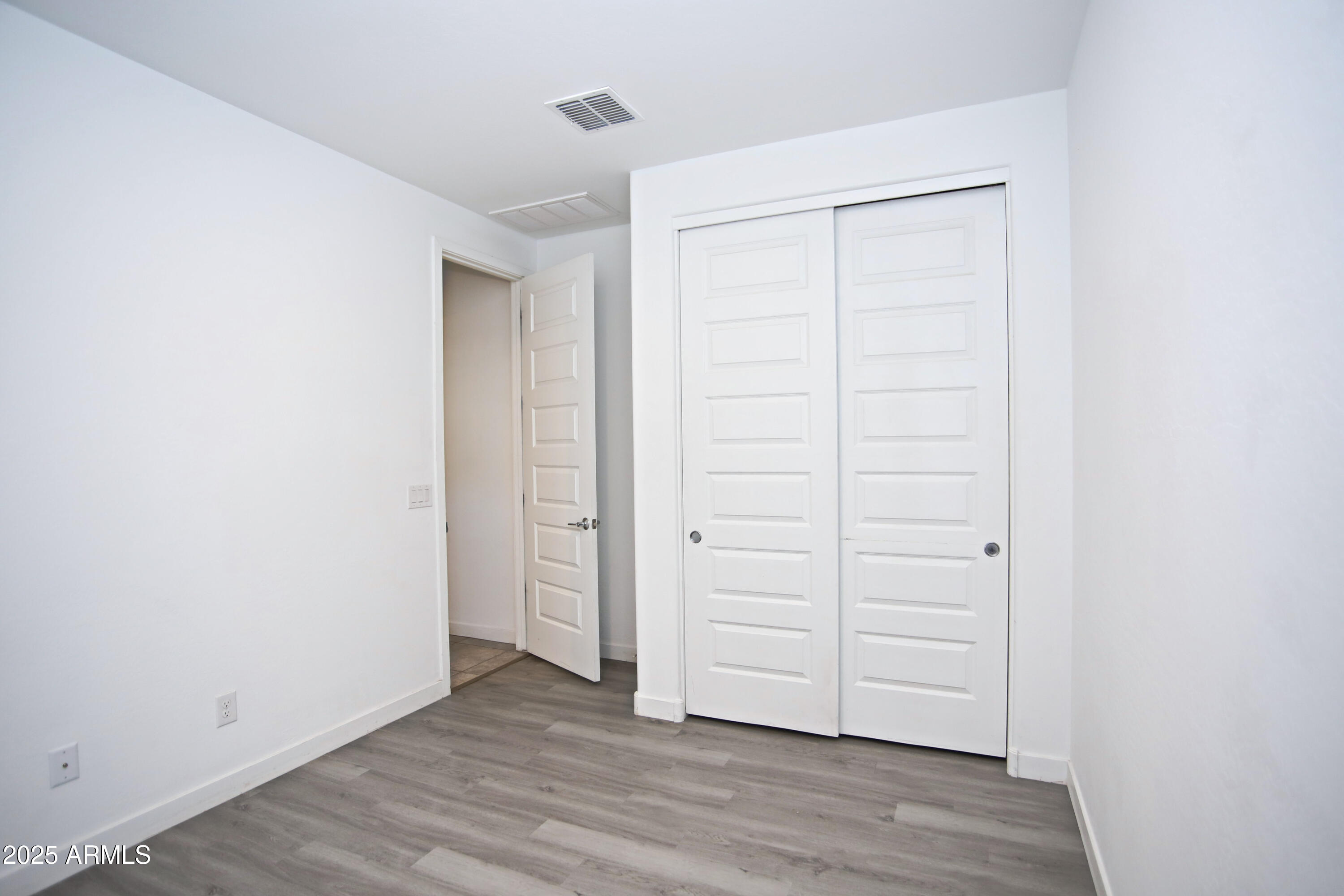 1535 West Corral Road Phoenix, AZ 85041 - Photo 9 of 39 an empty room with wooden floor