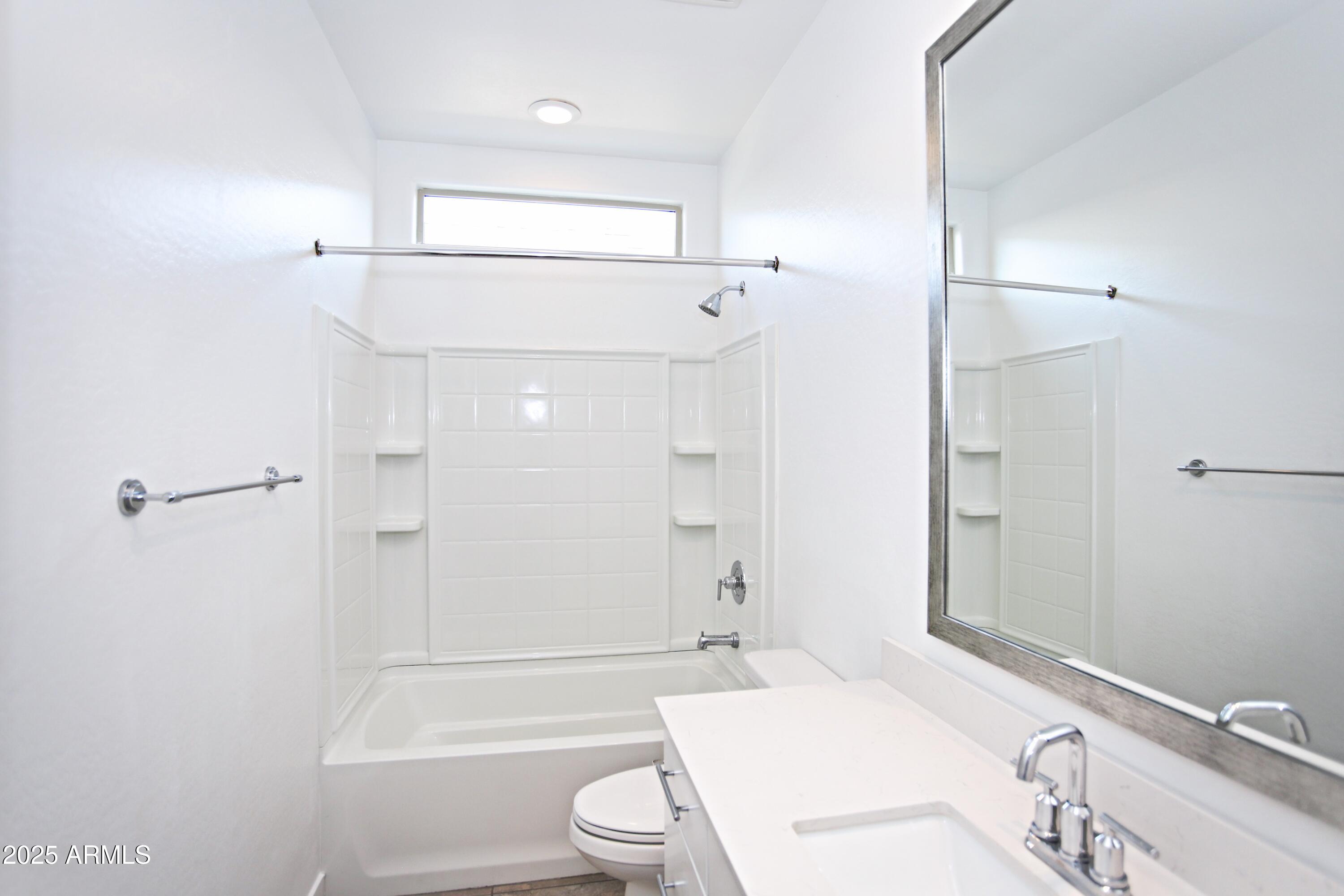 1535 West Corral Road Phoenix, AZ 85041 - Photo 10 of 39 a bathroom with a bathtub shower sink vanity and toilet