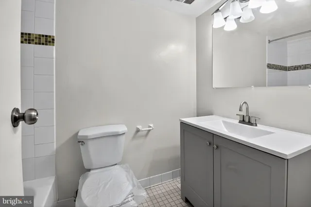 a bathroom with a toilet a sink a mirror and vanity