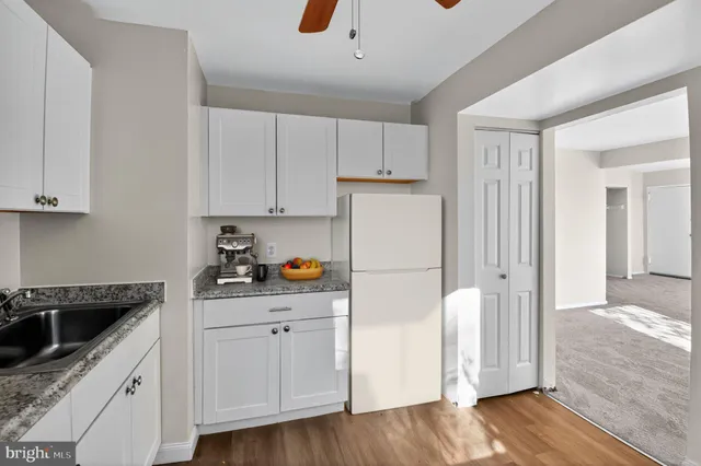 a kitchen with granite countertop a sink a counter space and cabinets