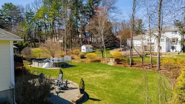 a view of swimming pool with lawn chairs and plants