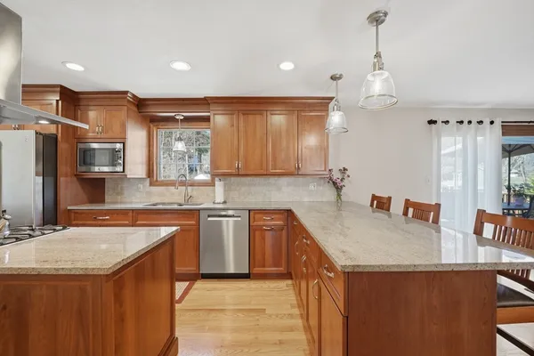 a kitchen with stainless steel appliances granite countertop a sink a stove and a refrigerator
