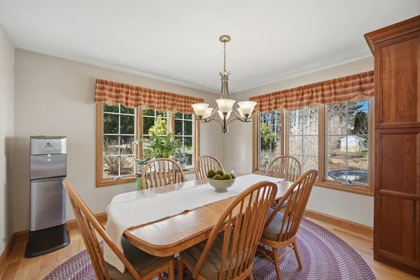 a dining room with furniture a chandelier and wooden floor