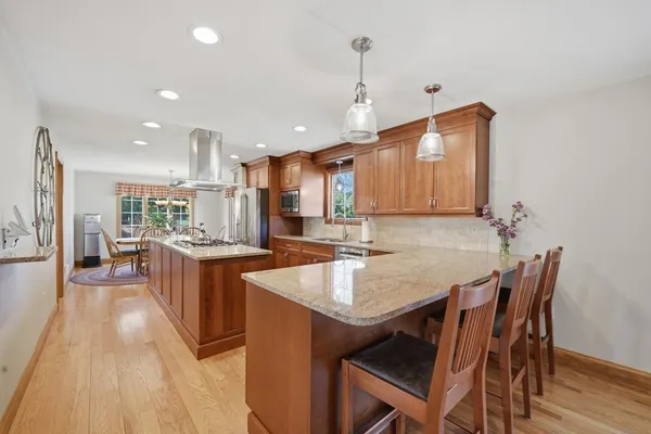 a kitchen with granite countertop kitchen island stainless steel appliances a table and chairs