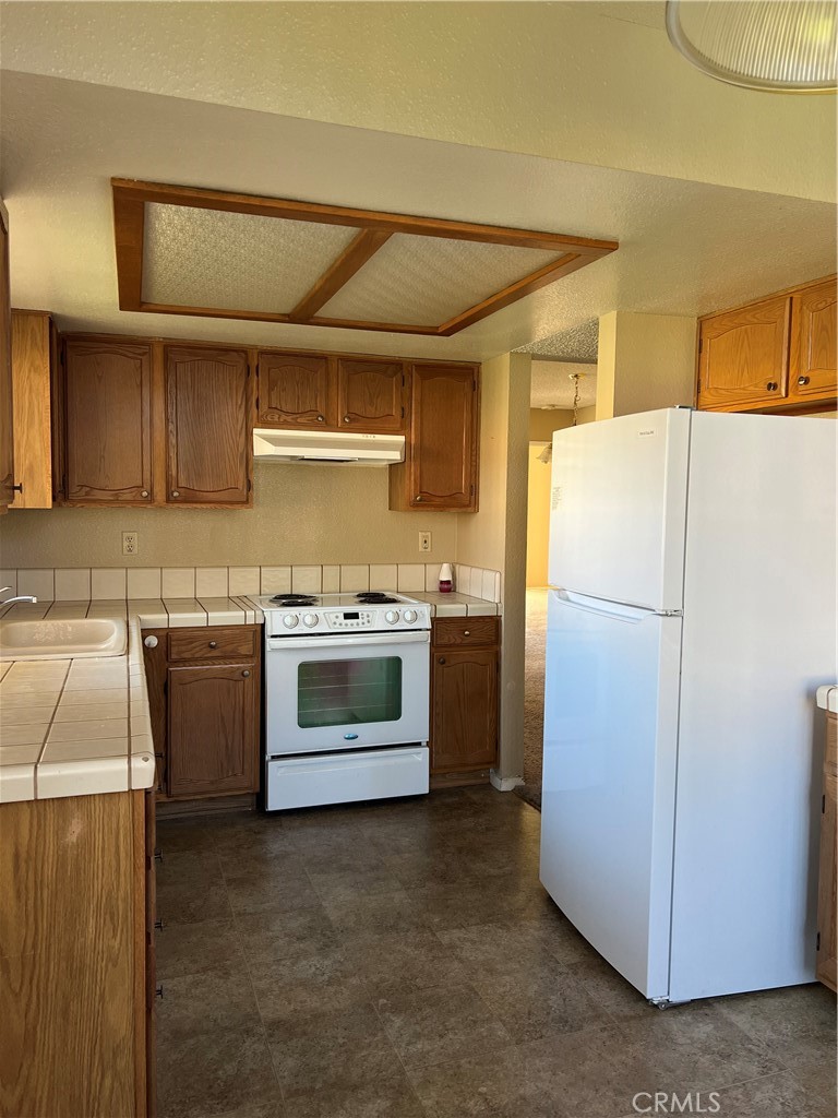 11687 Maple Street Apple Valley, CA 92308 - Photo 13 of 15 a kitchen with a refrigerator sink and stove