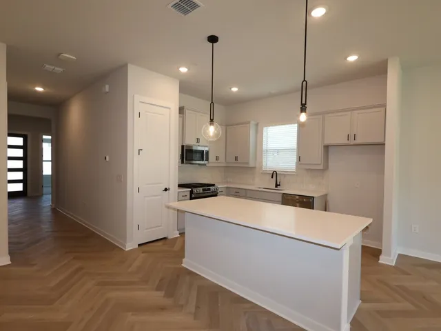 a large kitchen with stainless steel appliances granite countertop a sink a stove and a refrigerator