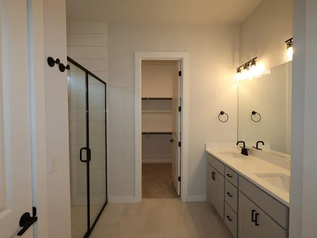 a bathroom with a double vanity sink a mirror and a shower