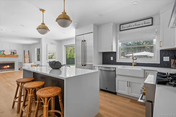 a kitchen with stainless steel appliances a dining table chairs sink and cabinets