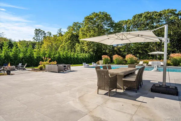 a view of a patio with table and chairs under an umbrella