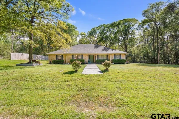 a front view of a house with yard and green space