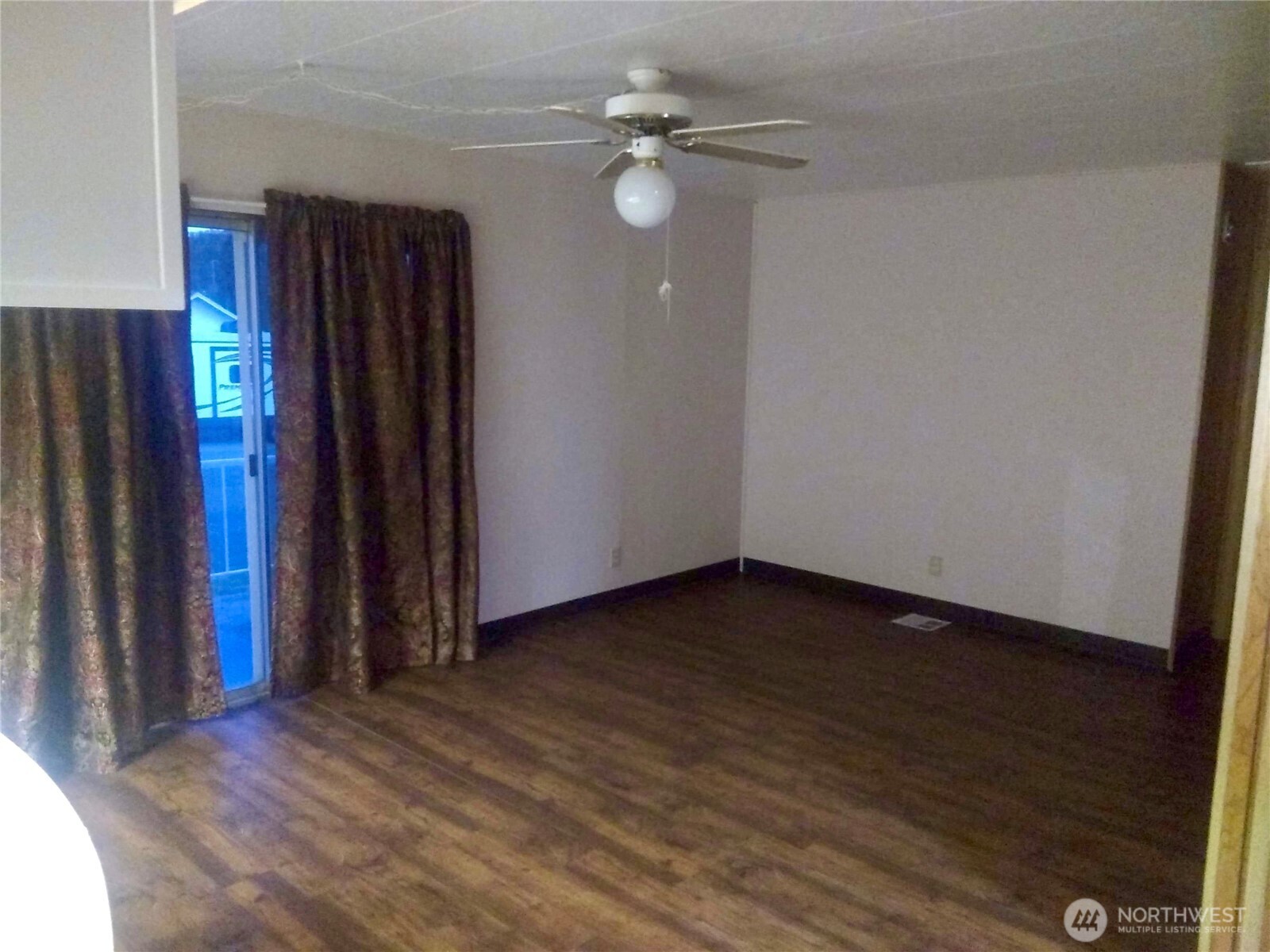 402 West 6th Avenue Ritzville, WA 99169 - Photo 9 of 19 an empty room with wooden floor and fan