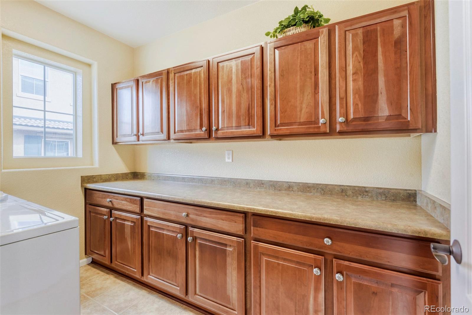 3355 Cascina Circle, Unit B Highlands Ranch, CO 80126 - Photo 22 of 28 a kitchen with granite countertop cabinets and window