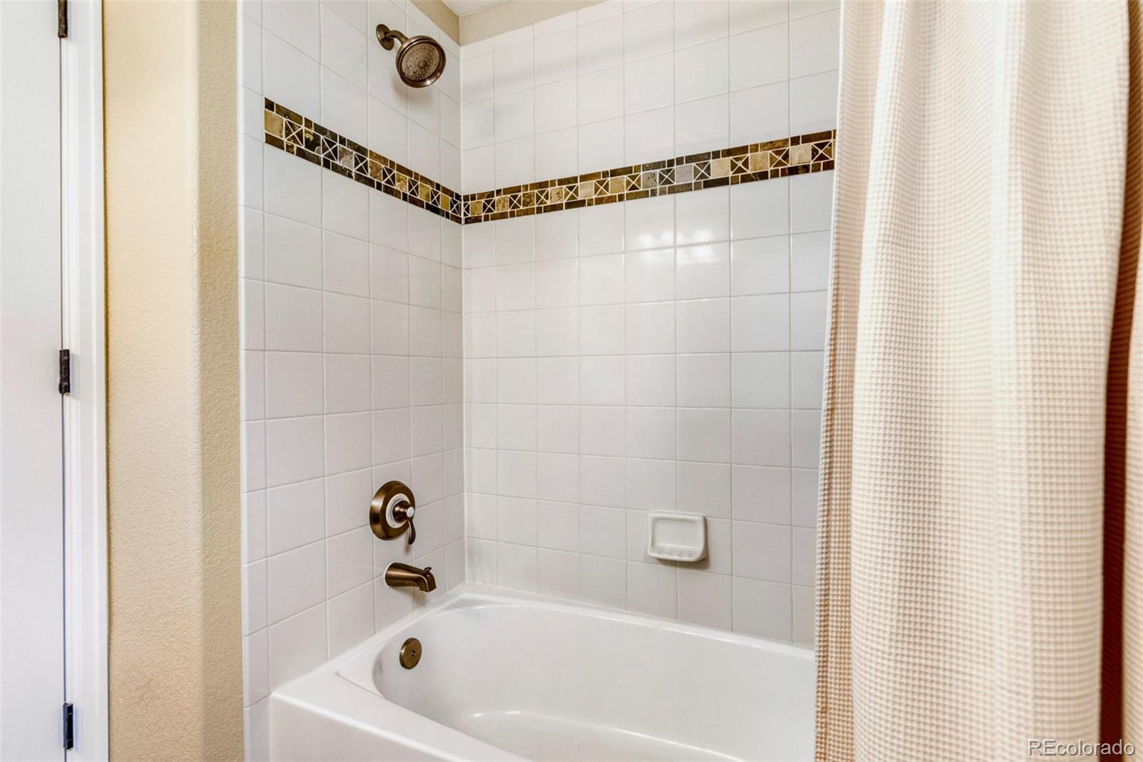 3355 Cascina Circle, Unit B Highlands Ranch, CO 80126 - Photo 27 of 28 a bathroom with a bathtub and a shower