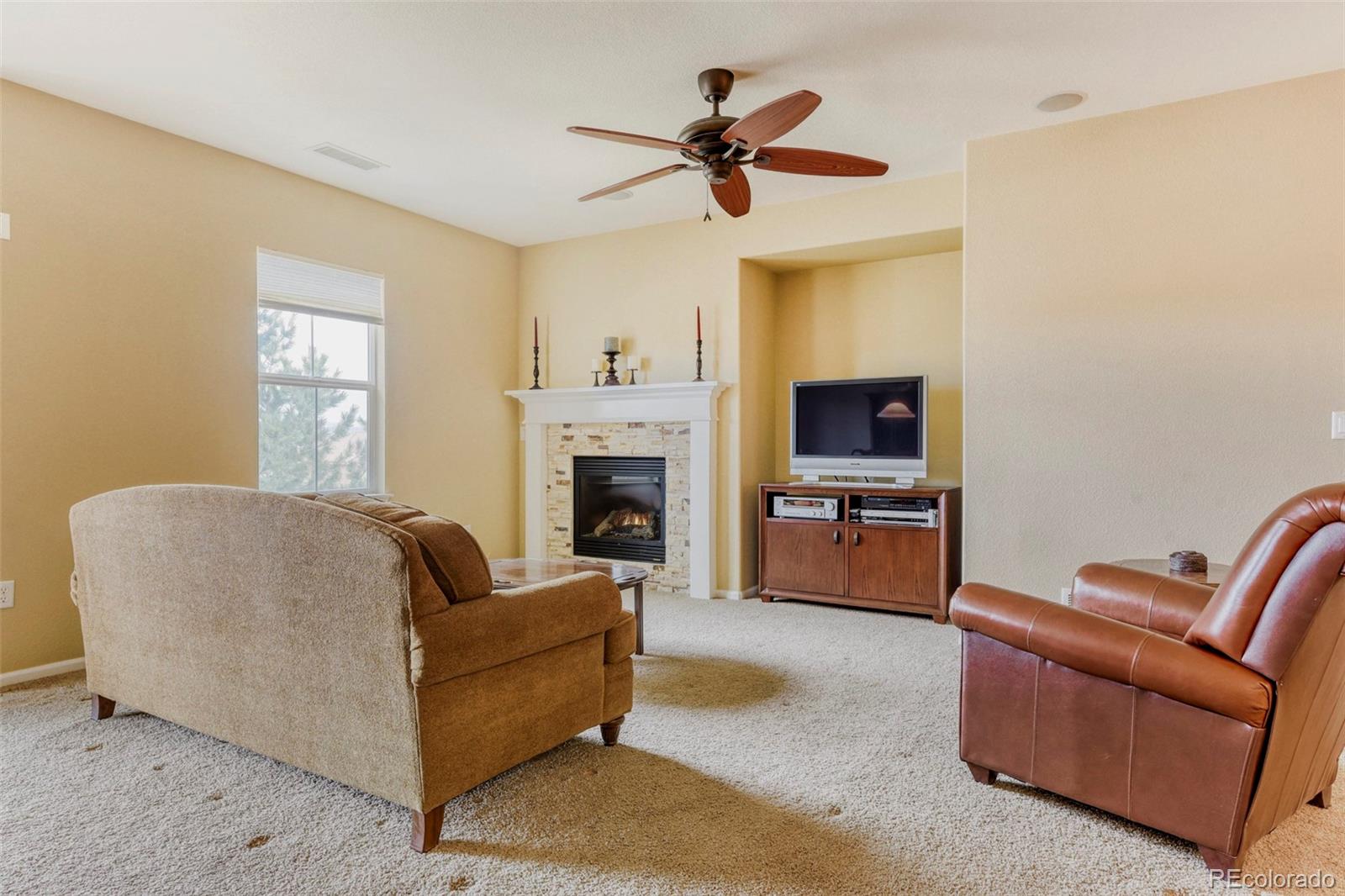 3355 Cascina Circle, Unit B Highlands Ranch, CO 80126 - Photo 5 of 28 a living room with furniture a fireplace and a flat screen tv