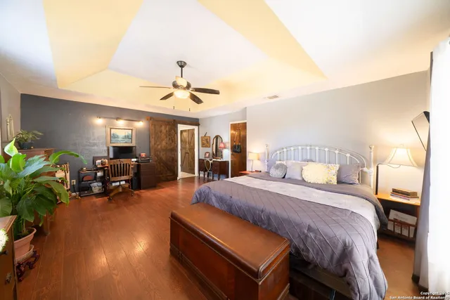 a spacious bedroom with a bed and a chandelier