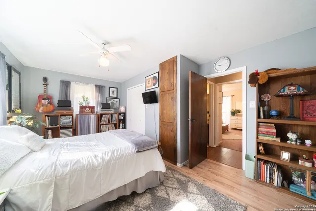 a large bedroom with bed and wooden floor