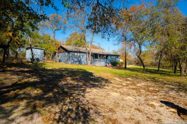 a view of swimming pool with outdoor seating and trees in the background